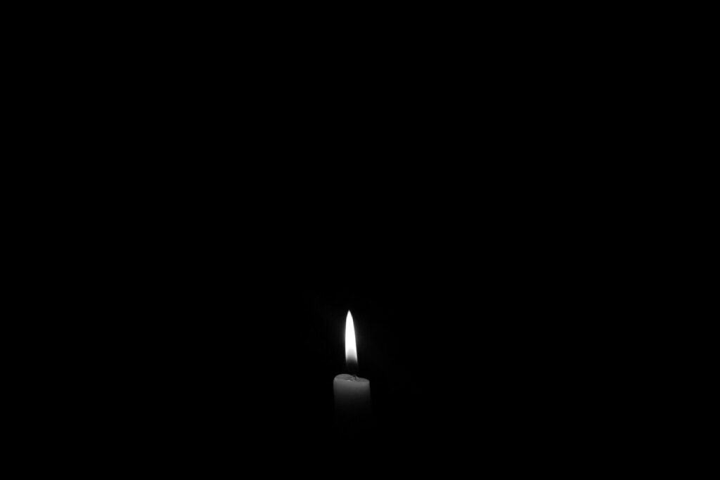 pexels-photo-695644-695644 A solitary candle flame against a plain black backdrop, epitomizing simplicity and tranquility.